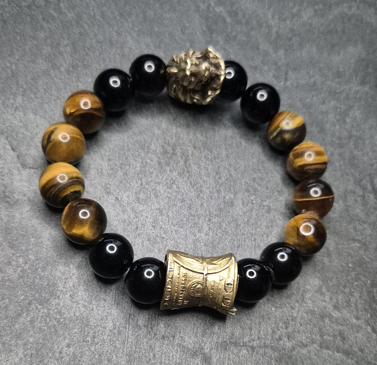Herrenarmband „CashKing“ in Braun mit Tigerauge, schwarzem Onyx und goldfarbener Geldrolle. 12 mm Perlen. Dominantes Design. Handmade in Germany.