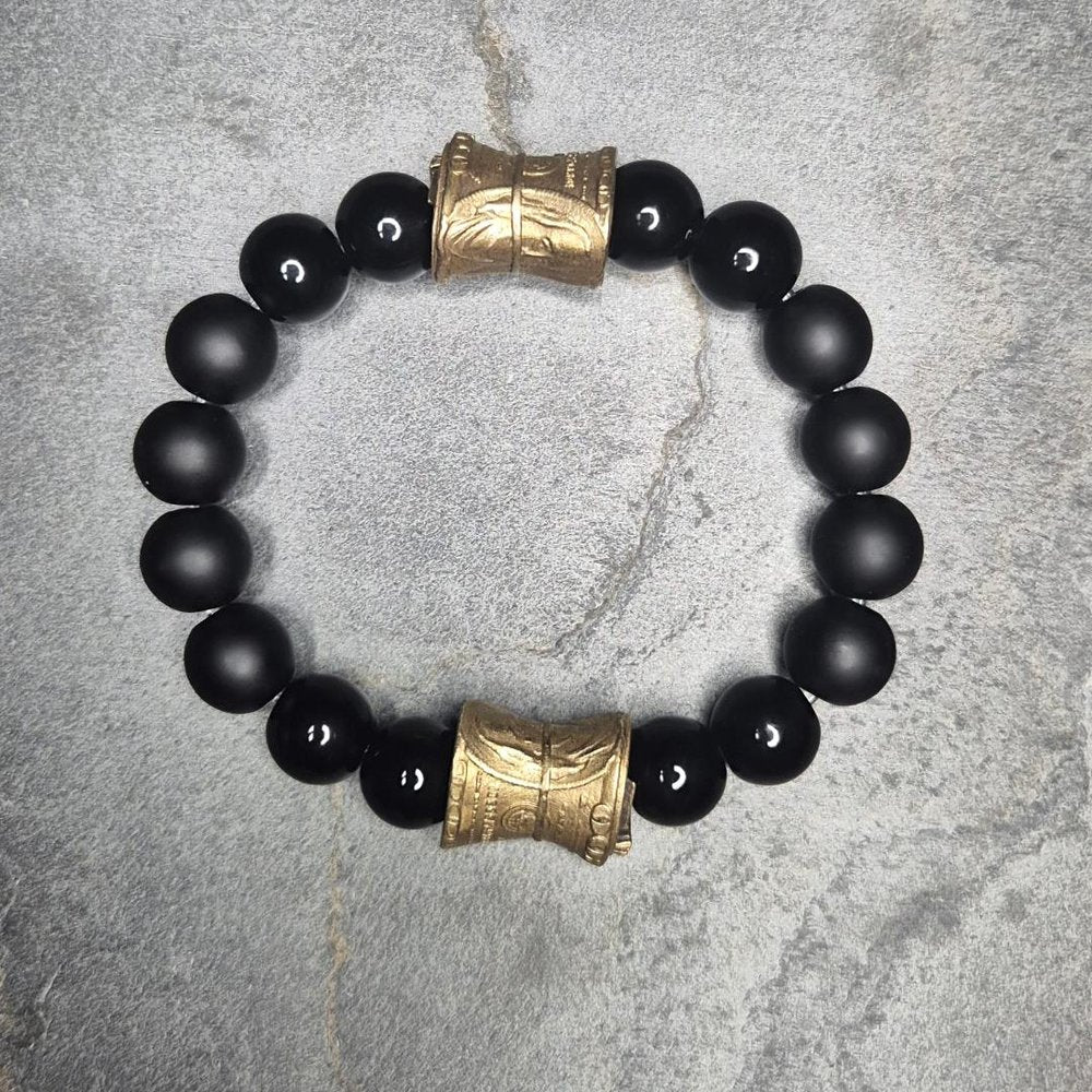 Markantes Perlenarmband aus schwarzem Onyx mit goldfarbener Geldrolle, Perspektive leicht schräg von vorne