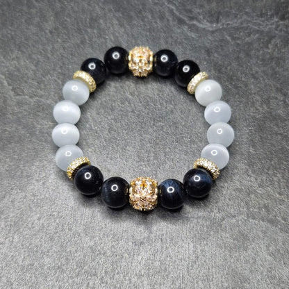NightVision Armband mit dunkelblauem Falkenauge, weißem Katzenauge und vergoldeten Blütenelementen (925 Silber). Handgemacht in Deutschland. XS–XXXL.