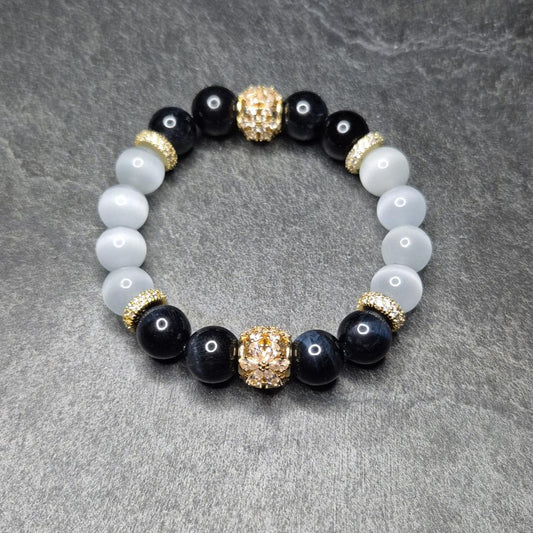 NightVision Armband mit dunkelblauem Falkenauge, weißem Katzenauge und vergoldeten Blütenelementen (925 Silber). Handgemacht in Deutschland. XS–XXXL.